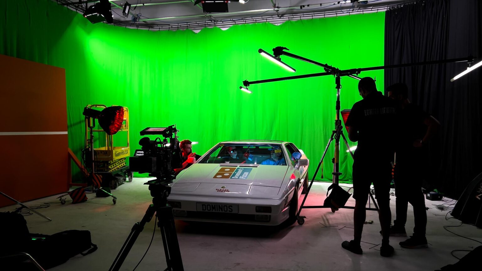 Green screen studio featuring Chroma key background, professional camera on dolly, and studio lights for video and film production